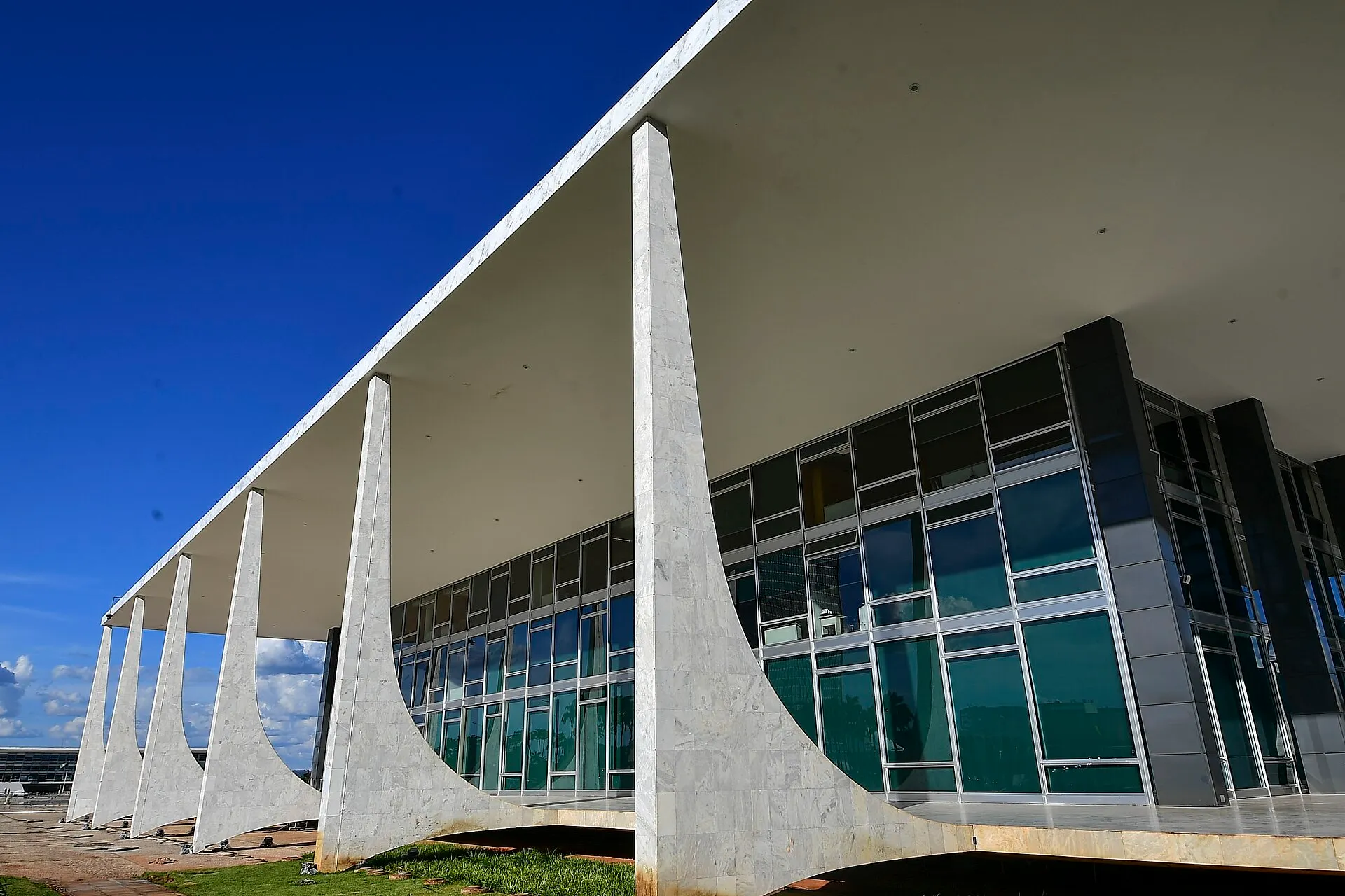 Fachada do Supremo Tribunal Federal, em Brasília, com grandes colunas de mármore branco sob céu azul.