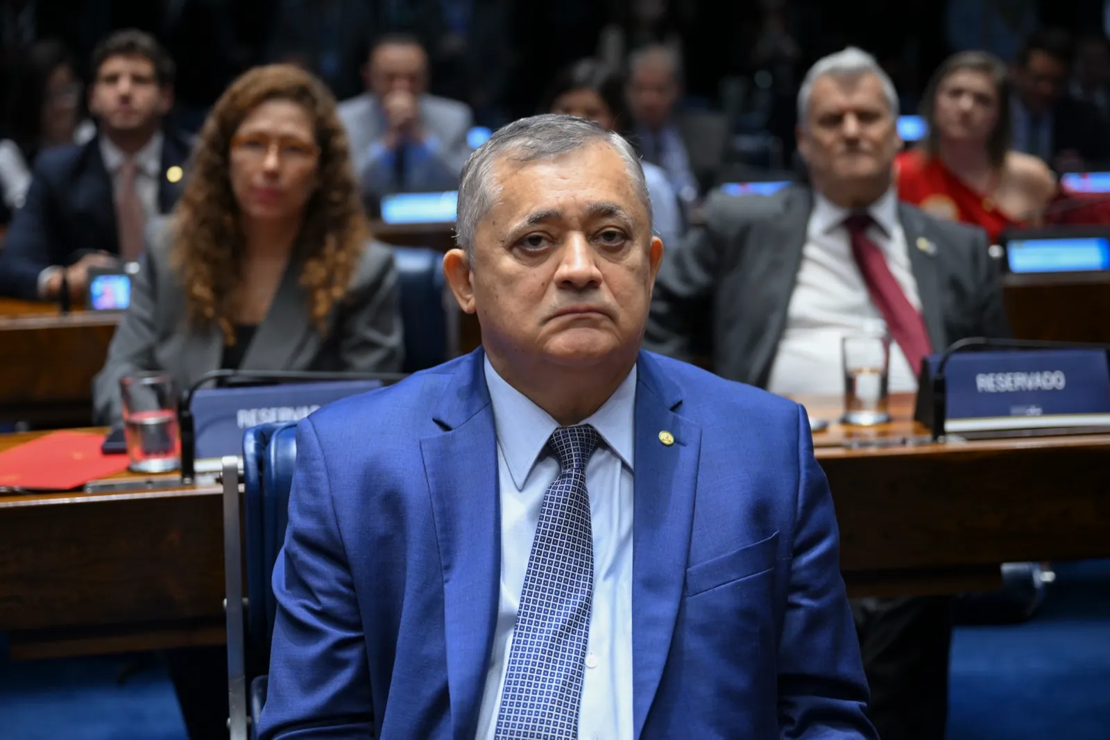 José Guimarães, de terno azul, sentado no plenário do Senado durante sessão solene.