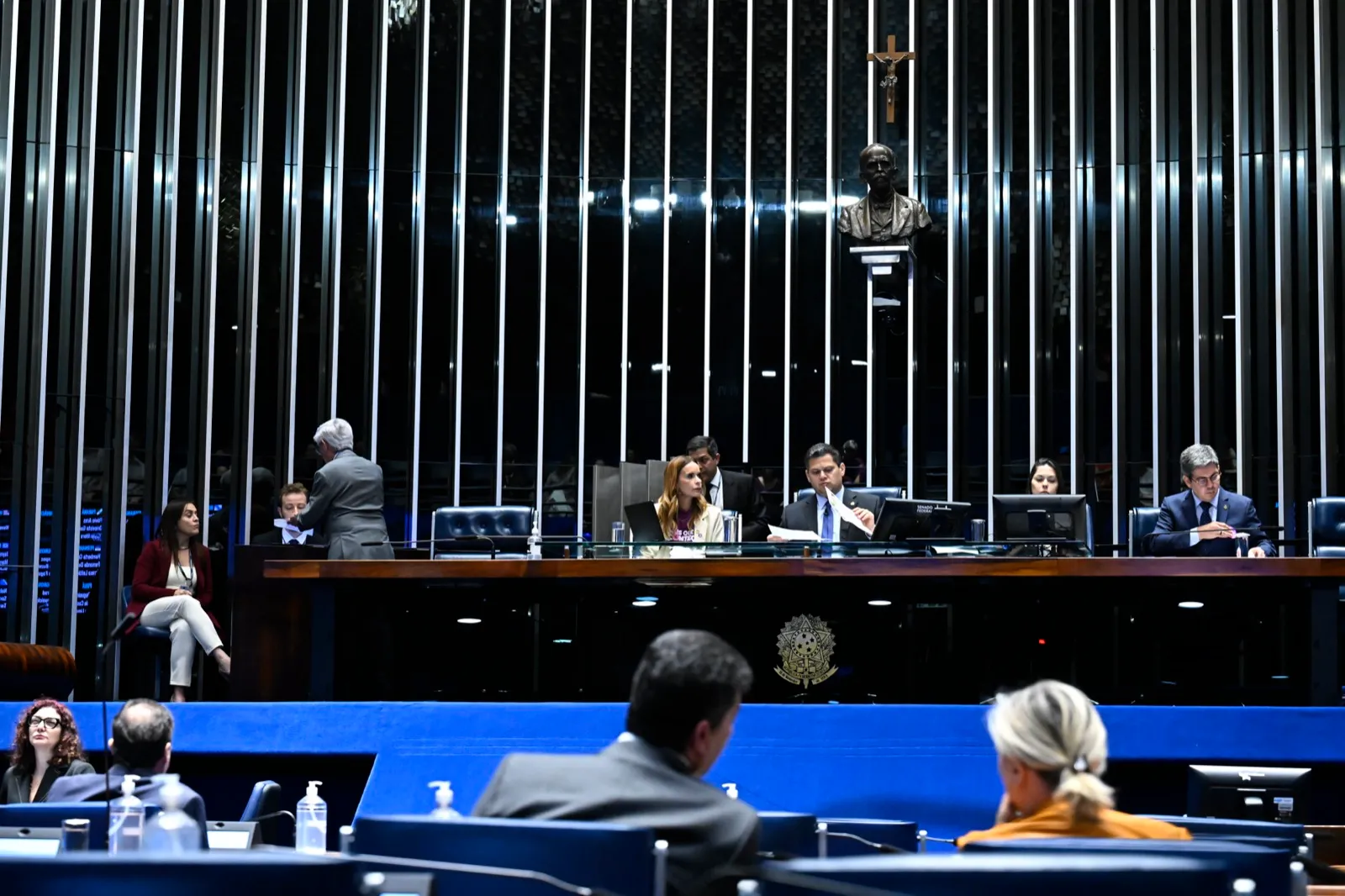 Mesa diretora do Plenário do Senado durante sessão, com o presidente Davi Alcolumbre ao centro e senadores sentados em primeiro plano.