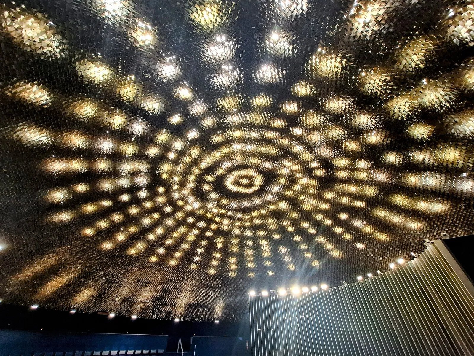 Teto do Plenário do Senado Federal, em Brasília, com lâminas douradas iluminadas vistas de baixo.